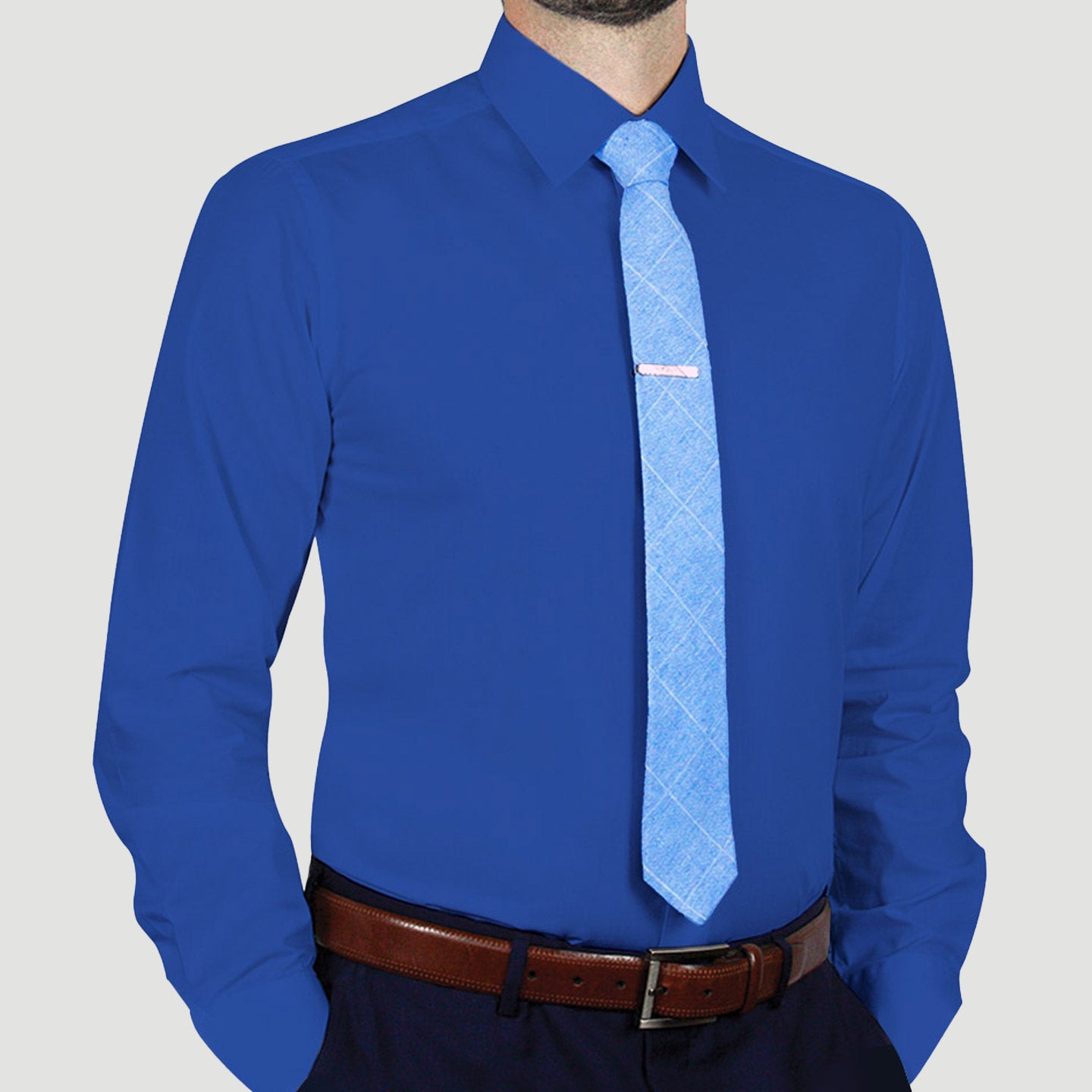 A person wearing an ARTURO Modern Fit Long Sleeve Royal Dress Shirt, complemented by a light blue tie and a brown belt, stands against a plain background.