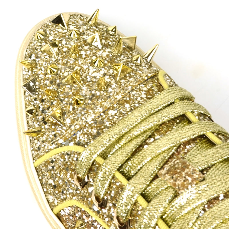 Introducing the FI-2429 Gold Glitter Gold Spikes Low Cut Sneaker Encore by Fiesso: This dazzling sneaker from Fiesso boasts a leather upper adorned with metallic spikes and studs on the toe and sides, complemented by a cushioned insole for ultimate comfort.