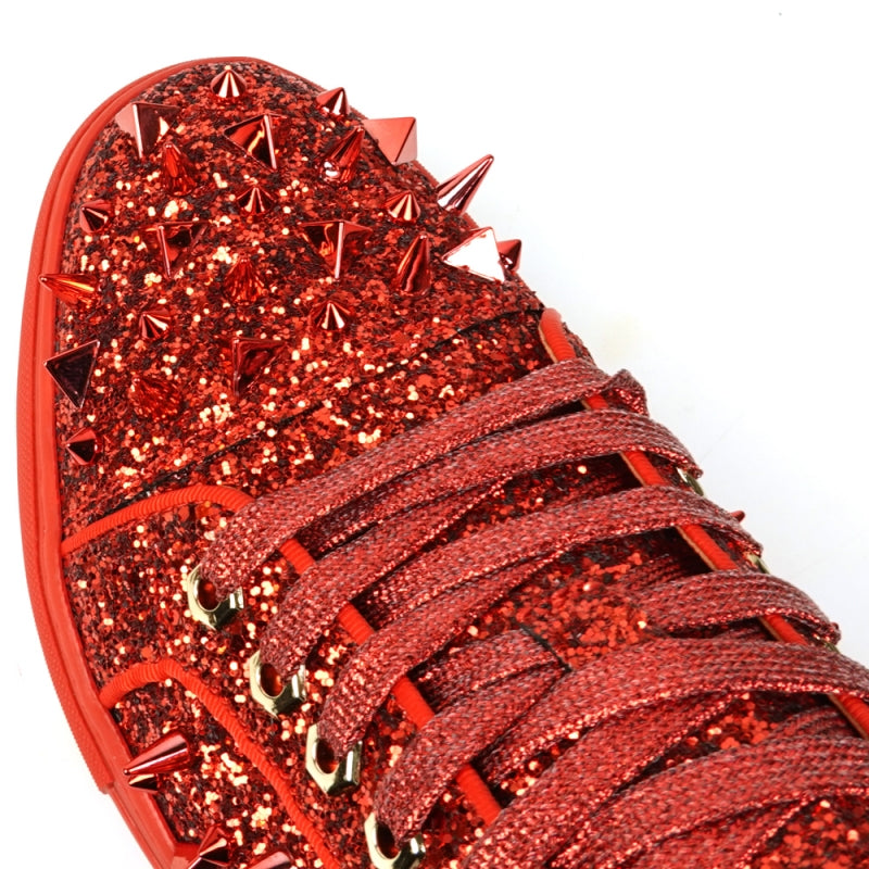 A close-up of the FI-2429 Red Glitter Red Spikes Low Cut Sneaker Encore by Fiesso showcases its dazzling red glitter, bold metal spikes, and matching shoelaces.