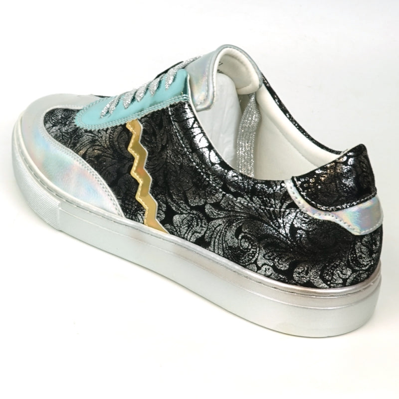 Step up your style with the FI-2431 Silver Multi Lace-Up Low Cut Sneaker Encore by Fiesso, showcasing a dynamic design that includes shiny turquoise and silver sections, glittery silver laces, intricate black lace-like patterns, and an eye-catching gold zigzag detail on the side.