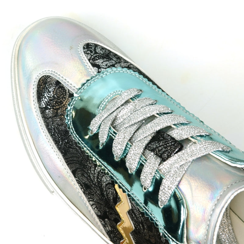 Step up your style with the FI-2431 Silver Multi Lace-Up Low Cut Sneaker Encore by Fiesso, showcasing a dynamic design that includes shiny turquoise and silver sections, glittery silver laces, intricate black lace-like patterns, and an eye-catching gold zigzag detail on the side.