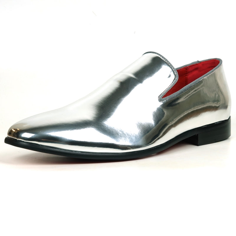 The FI-7548 Silver Patent Slip On Leafer by Fiesso embodies the sophistication of men's dress shoes with its sleek, shiny silver exterior and vibrant red interior complemented by a sturdy black sole. This elegant design seamlessly integrates the allure of vegan leather, offering both style and comfort with every step.