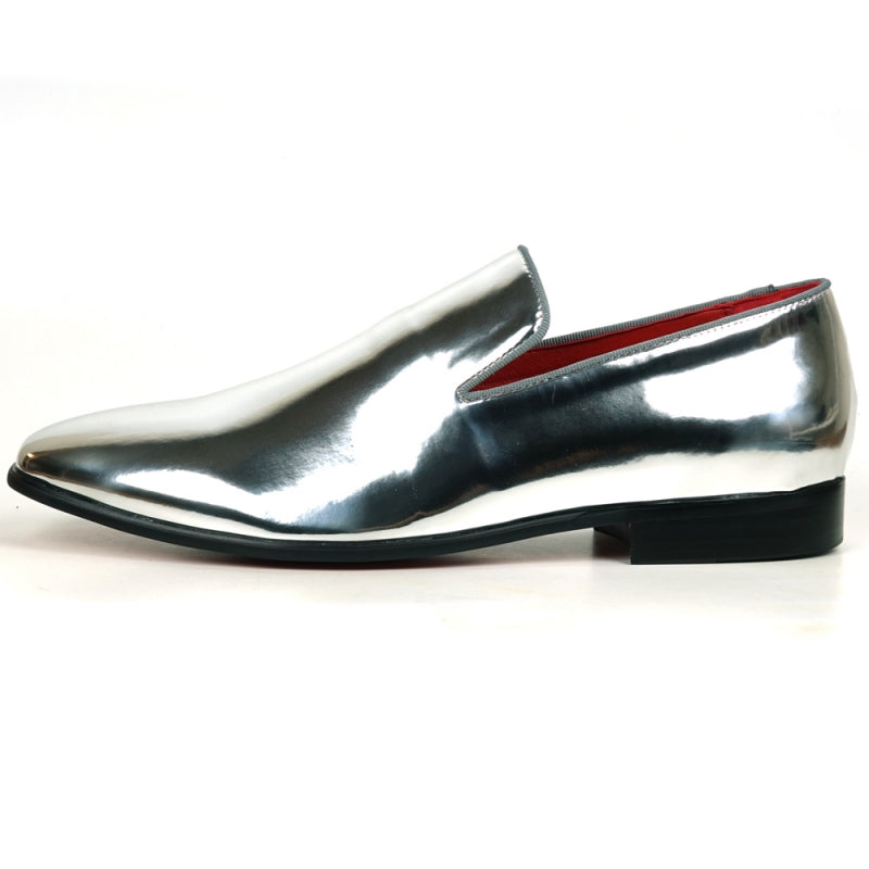 The FI-7548 Silver Patent Slip On Leafer by Fiesso embodies the sophistication of men's dress shoes with its sleek, shiny silver exterior and vibrant red interior complemented by a sturdy black sole. This elegant design seamlessly integrates the allure of vegan leather, offering both style and comfort with every step.