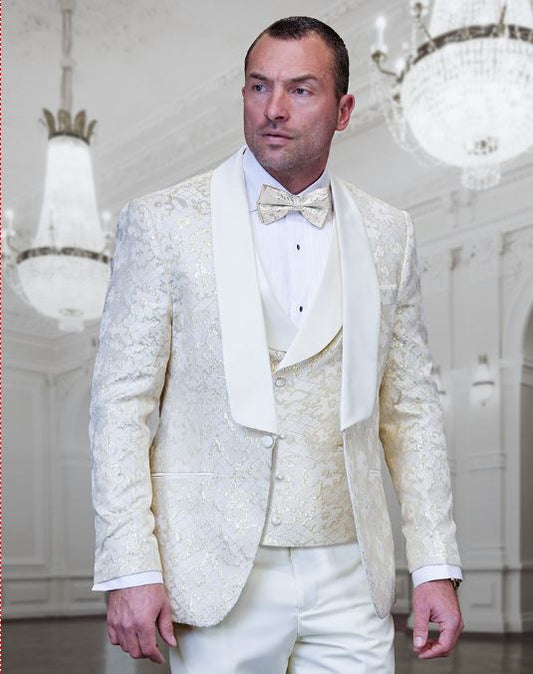 A man wearing the STATEMENT TIZANO OFF WHITE Suit by Inserch is standing in a room adorned with chandeliers and ornate decor.