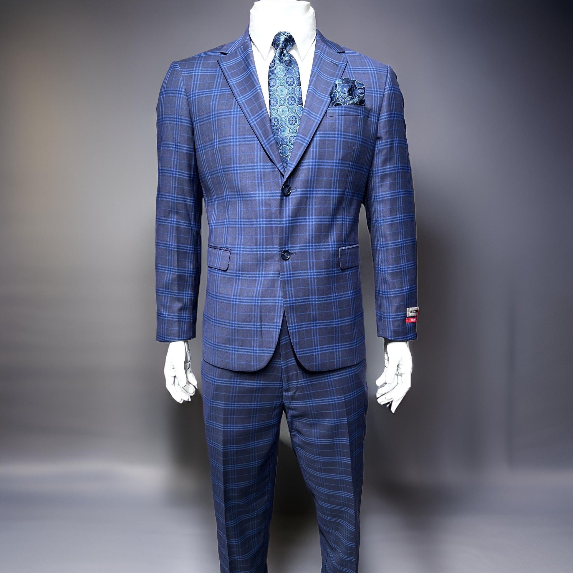 A mannequin features the Gianco Ferro Modern Fit Suit in light blue plaid by Unique Design Menswear, including a notch lapel jacket and flat front pants. The outfit is expertly accessorized with a coordinating tie and pocket square, set against a neutral background.