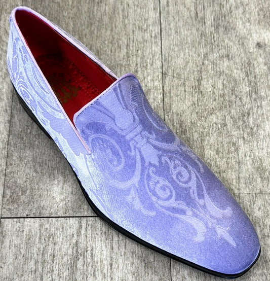 The Exclusive Formal Dress Shoe Lavender Paisley 7017 by UNIQUE DESIGN MENSWEAR is a slip-on crafted from genuine leather in a light purple hue, showcasing a subtle paisley pattern and elegantly resting on a wooden floor.