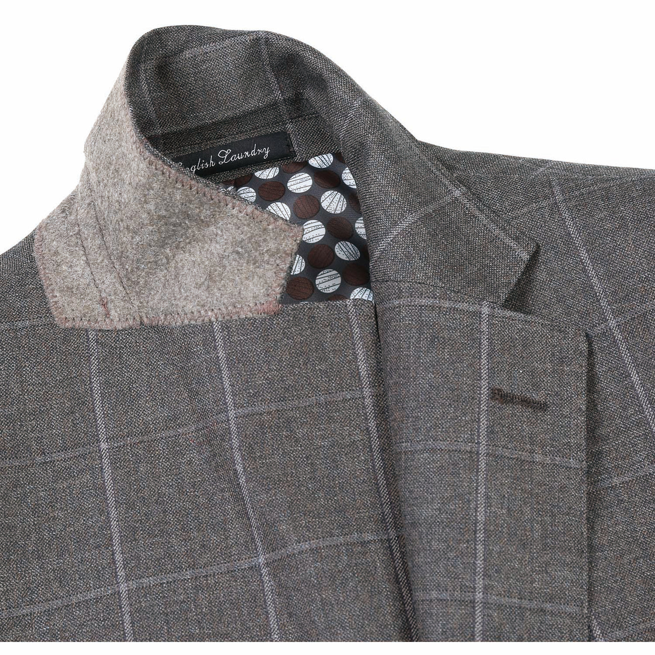 A brown wool suit jacket from English Laundry, featuring notch lapels and a slim fit, is displayed on a mannequin along with a light peach tie and white shirt. This ensemble is crafted from 80% wool.