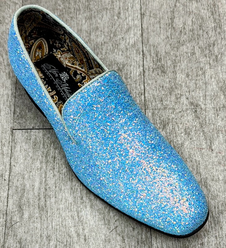 An Exclusive Formal Dress Shoe Light Blue BARNES by UNIQUE DESIGN MENSWEAR, featuring a glitter-covered exterior and patterned interior, rests on a gray wooden floor, crafted from genuine Italian leather for an exquisite touch.