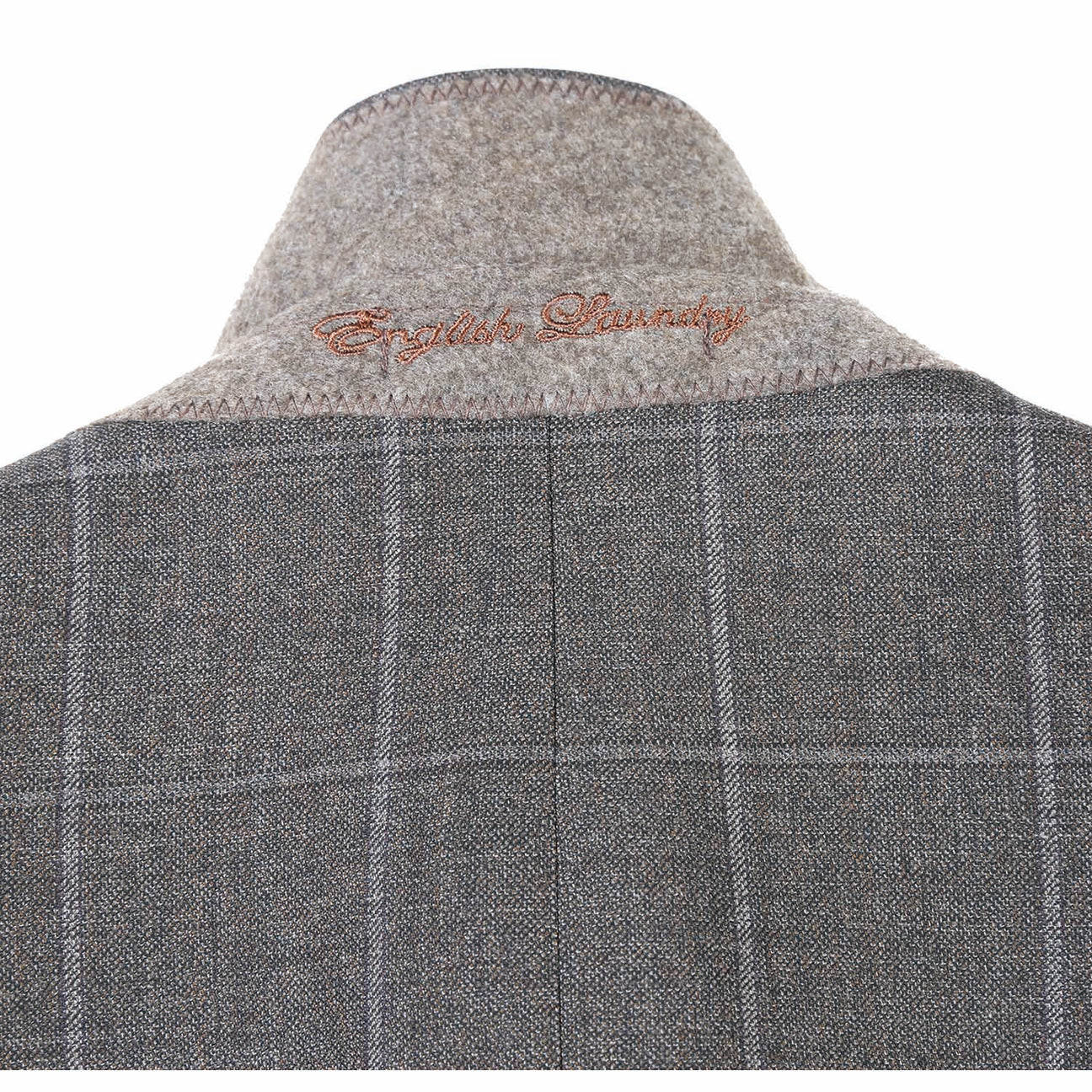 A brown wool suit jacket from English Laundry, featuring notch lapels and a slim fit, is displayed on a mannequin along with a light peach tie and white shirt. This ensemble is crafted from 80% wool.