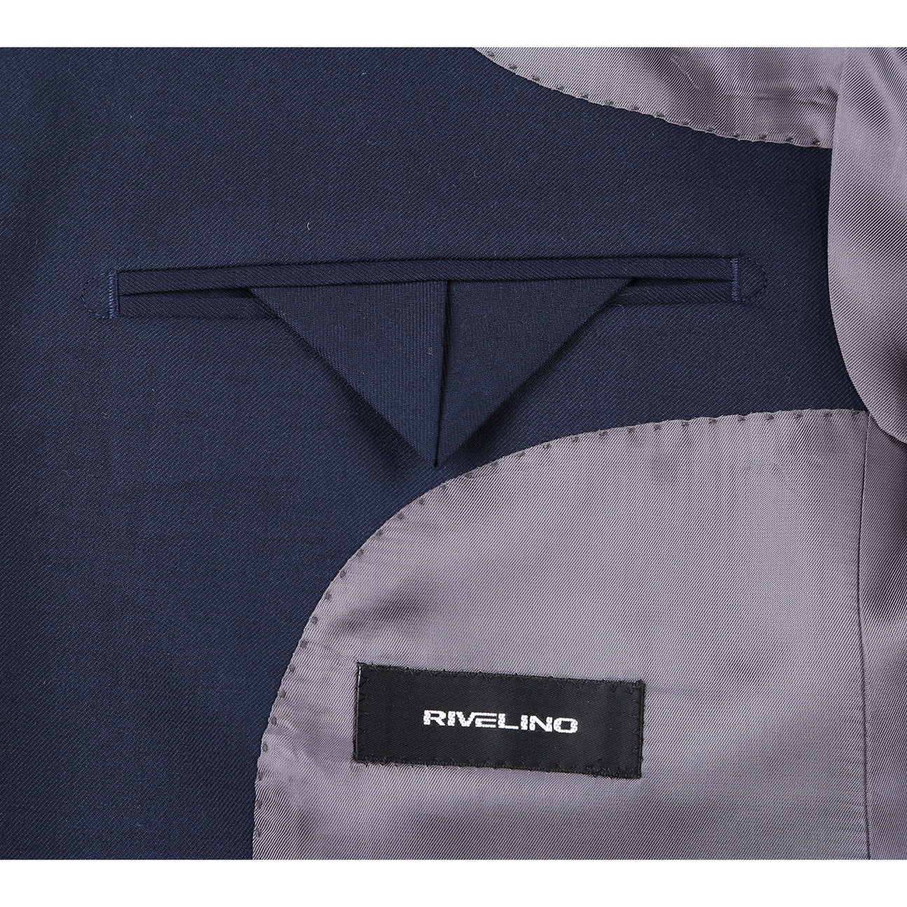 Introducing the RIVELINO Modern Fit Navy Half-Canvas Suit RHC100-2 by Rivelino, a sleek dark blue single-breasted jacket with two buttons. This stylish piece is crafted from a luxurious blend of wool spandex fabric and features a smooth light gray lining.