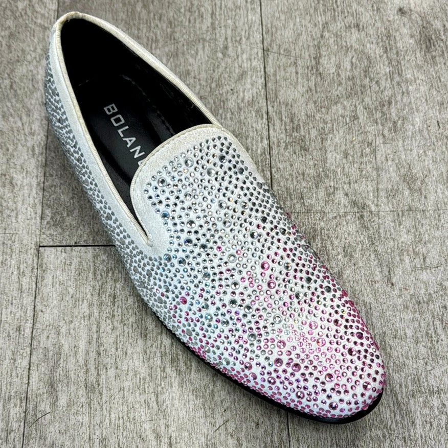 A single slip-on shoe, adorned with rhinestones and crafted from genuine leather, with a fading pink pattern on the toe area, elegantly displayed on a wooden floor. This sparkling piece is by UNIQUE DESIGN MENSWEAR and part of their Exclusive Formal Dress Shoe Lavender / White FROST collection.