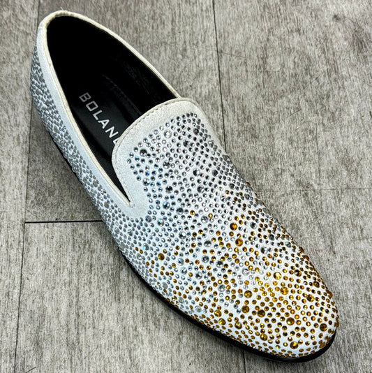 Introducing the Exclusive Formal Dress Shoe Gold/White FROST by UNIQUE DESIGN MENSWEAR: a slip-on shoe featuring a gradient pattern of small metallic studs, transitioning from silver at the heel to gold at the toe. Crafted from genuine leather and elegantly displayed on a light wood floor.