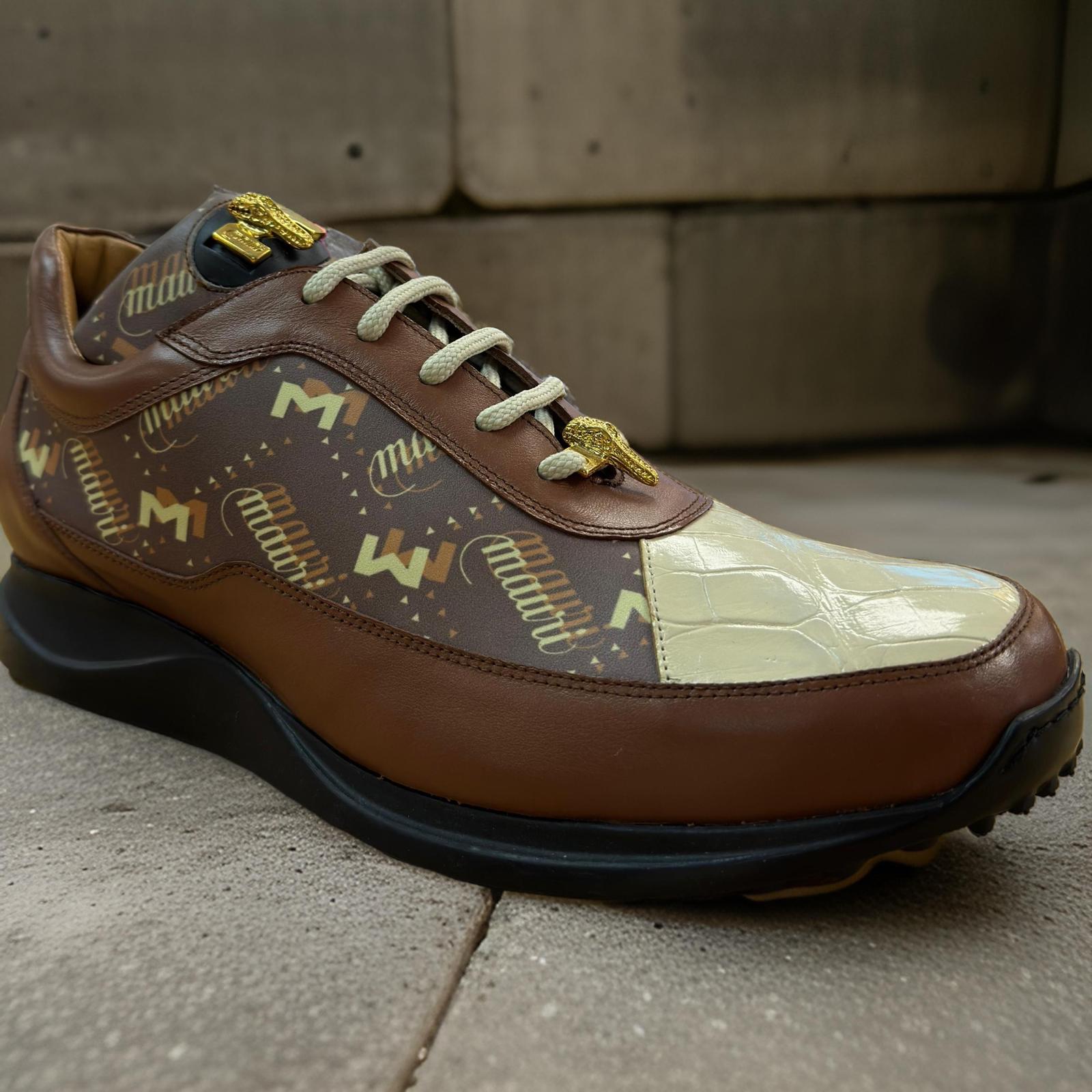 A close-up of the Mauri 8900 Light Brown/Tan shoe, highlighting its textured brown leather with cream accents, patterned design, and baby crocodile details, set against a concrete background. Available in sizes 9, 9.5, and 13 only as a final sale item from Mauri.