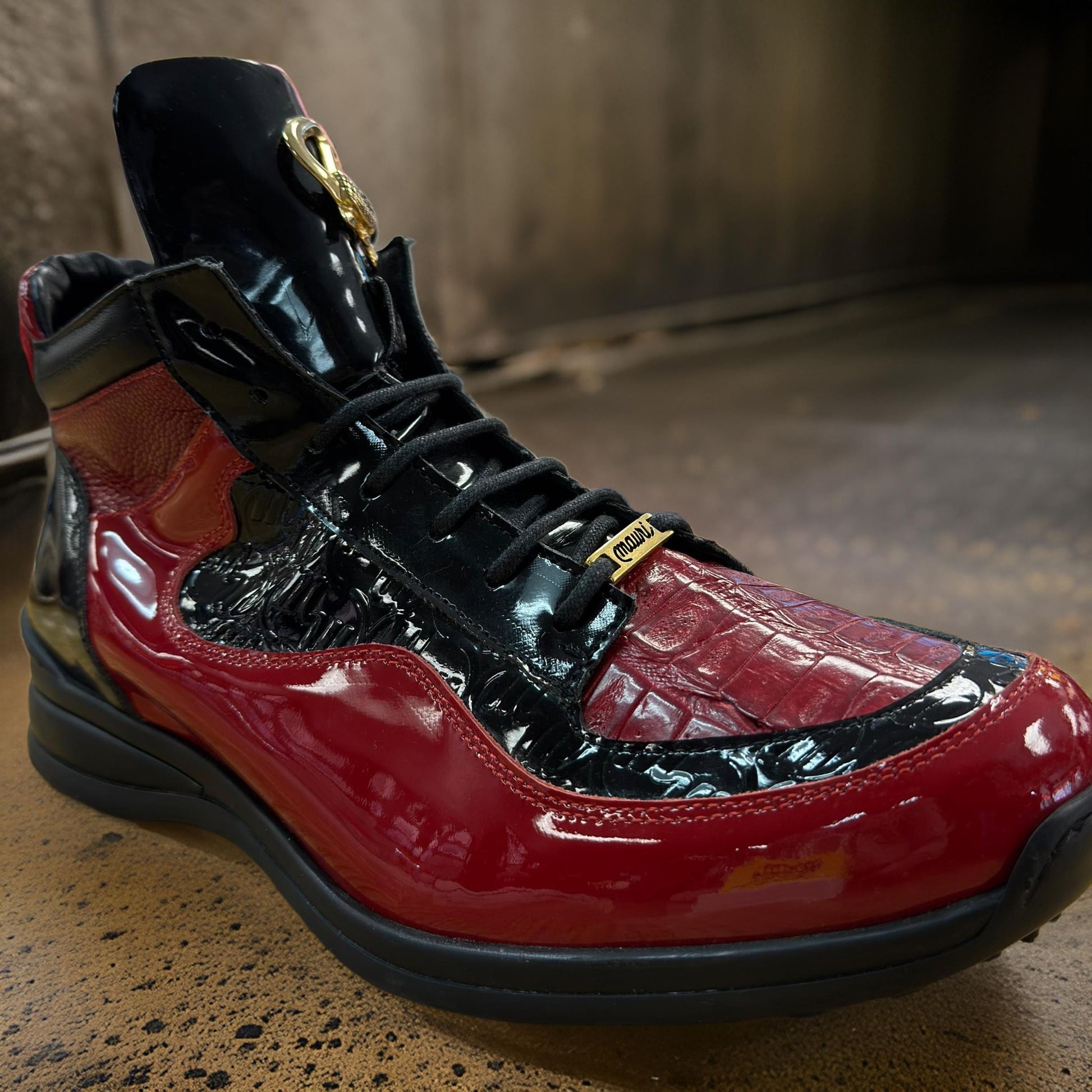 A pair of Mauri 8401 Red/Black Patent Leather Boots, featuring shiny and textured details, is set on a concrete surface.