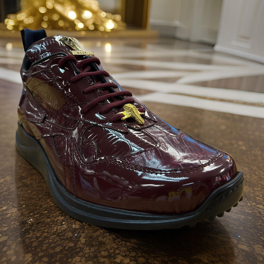 A pair of glossy Mauri 8464 burgundy patent leather shoes, featuring a gold embellishment on the laces, is elegantly displayed on a polished, patterned floor.