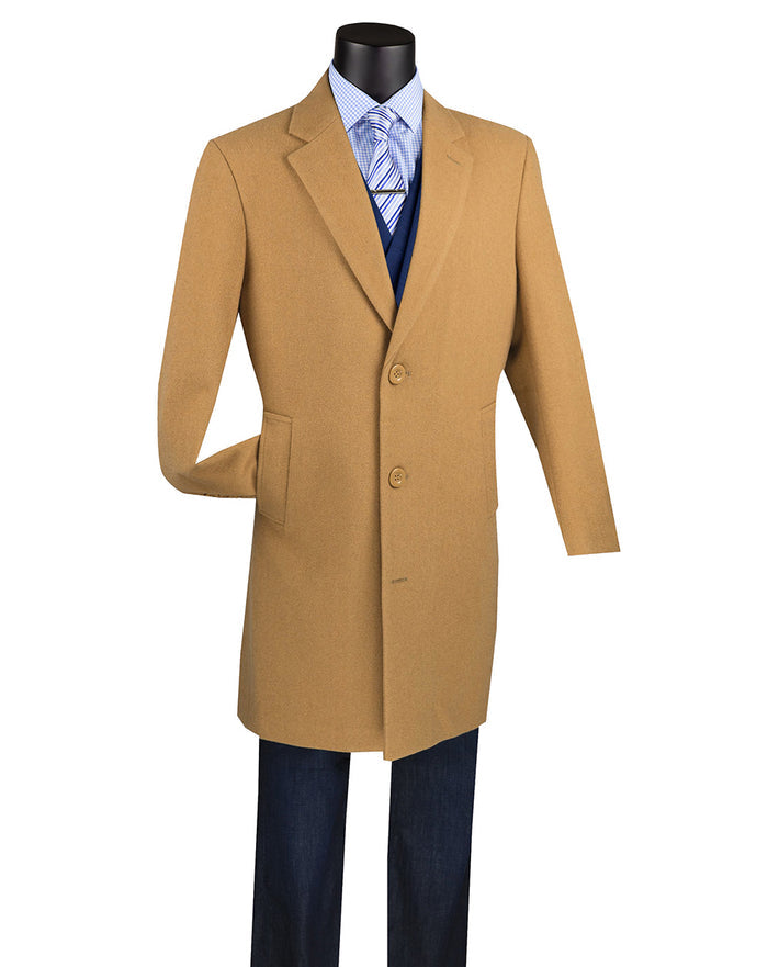 A mannequin showcases the Vinci Wool & Cashmere Regular Fit Top Coat 38" Long in Camel, crafted by Vinci Suits from a luxurious wool cashmere blend. It's styled with a blue shirt and tie underneath, paired elegantly with dark trousers.