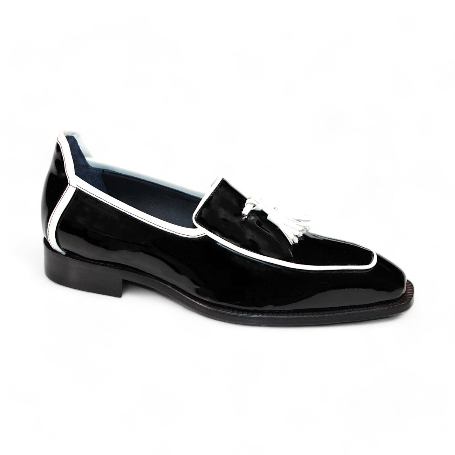 The Duca Di Matiste Fano loafer in black patent leather with white trim and tassel detailing, expertly crafted in Italy by Duca Di Matiste, is displayed against a pristine white background.