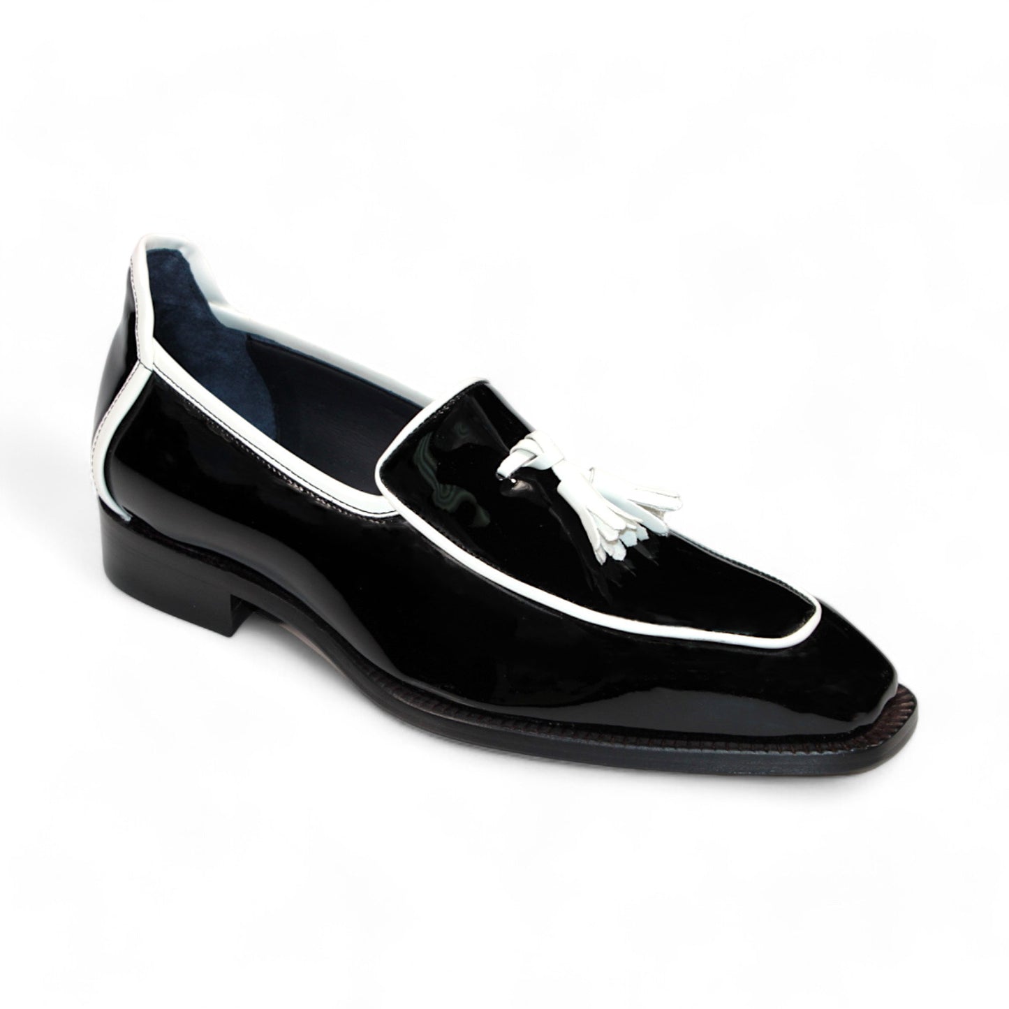 The Duca Di Matiste Fano loafer in black patent leather with white trim and tassel detailing, expertly crafted in Italy by Duca Di Matiste, is displayed against a pristine white background.