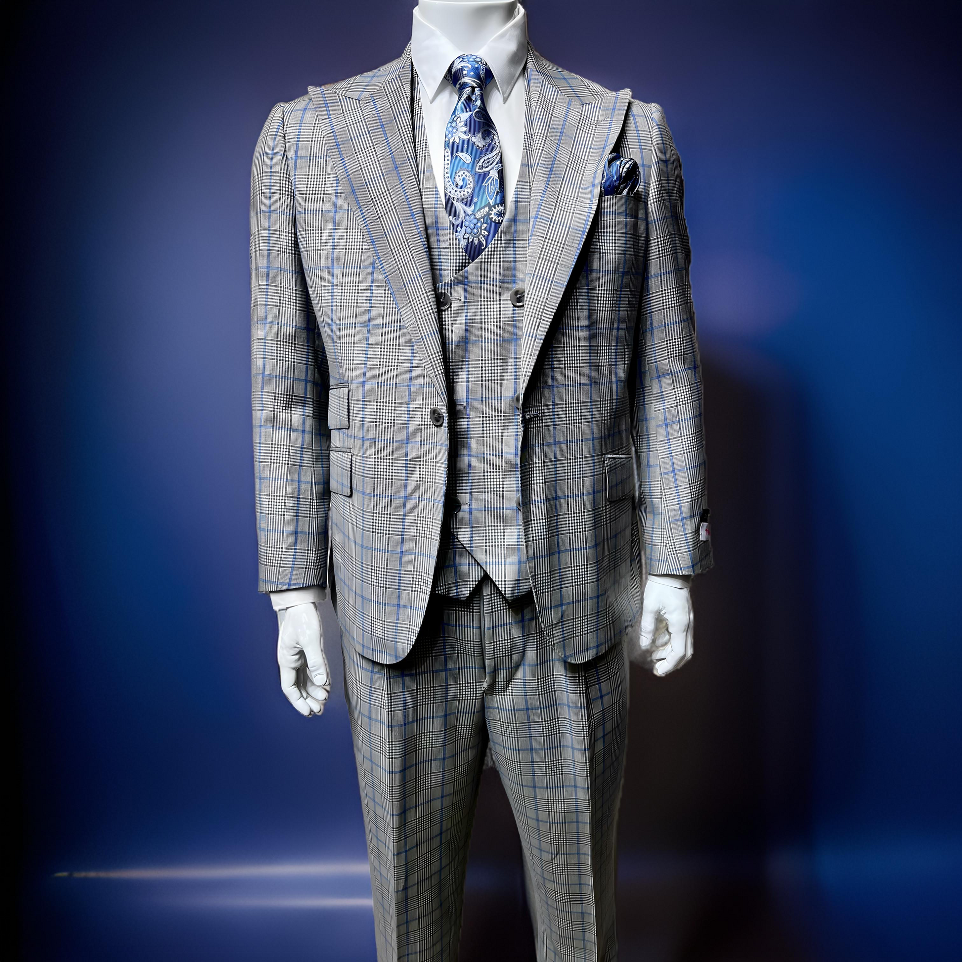 A mannequin showcases a striking Tiglio Rosso Orvietto suit, crafted from 100% wool. This three-piece gray plaid ensemble features a blue paisley tie and matching pocket square, all set against a dark blue background.