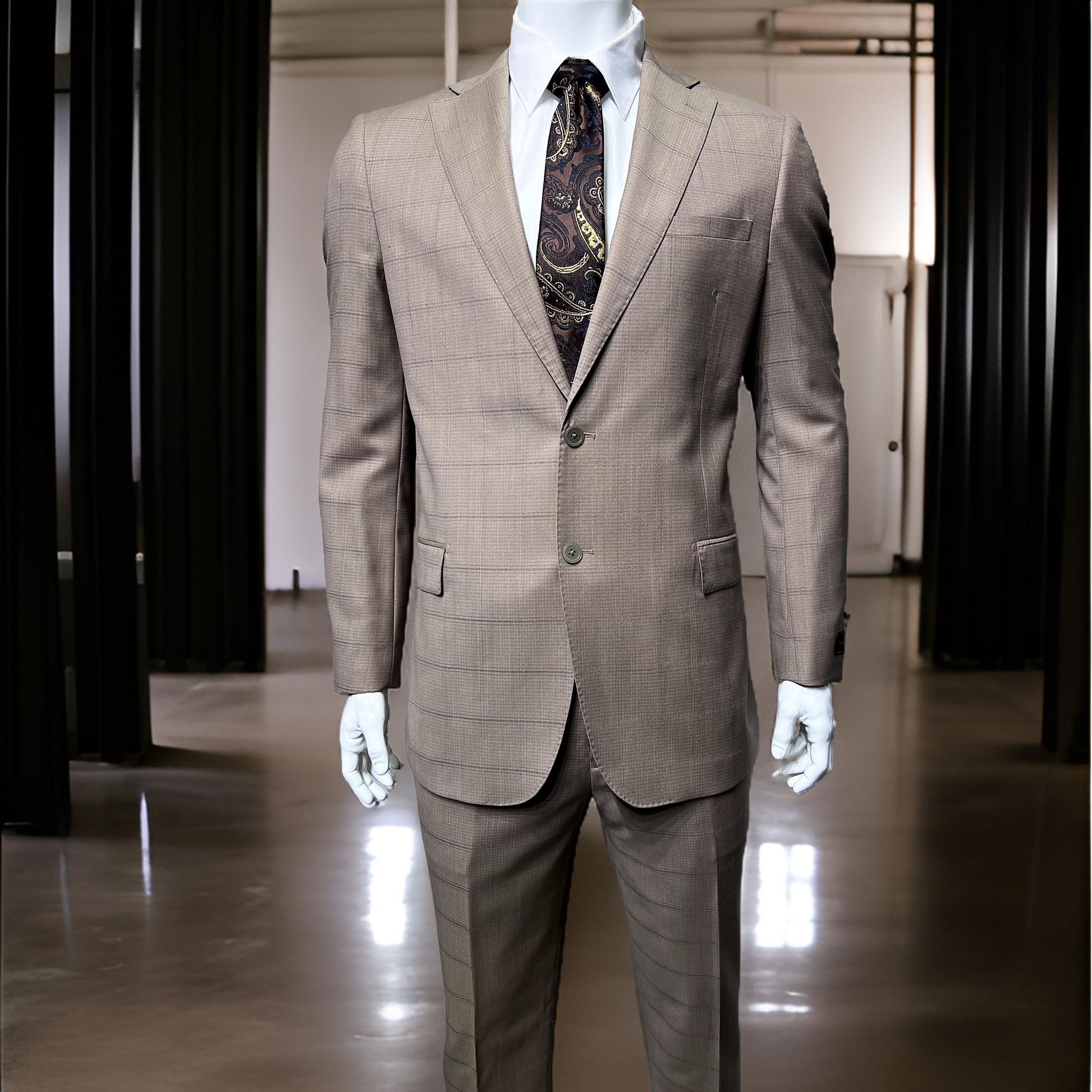 In a sleek, contemporary showroom with soft lighting, a mannequin is elegantly dressed in the Tiglio Luxe Dolcetto Slim Fit Tan Windowpane Suit (TL2501), made from pure Italian wool and complemented by a paisley tie, highlighting the sophistication of TIGLIO men's clothing.