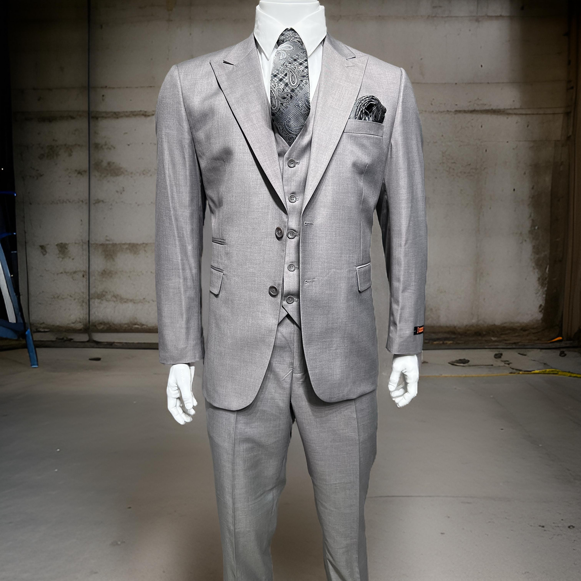 The Ideal Grey Suit & Vest RH15-3 from Unique Design Menswear is showcased on a mannequin, complete with a matching tie and pocket square, featuring a peak lapel jacket against a simple industrial backdrop.