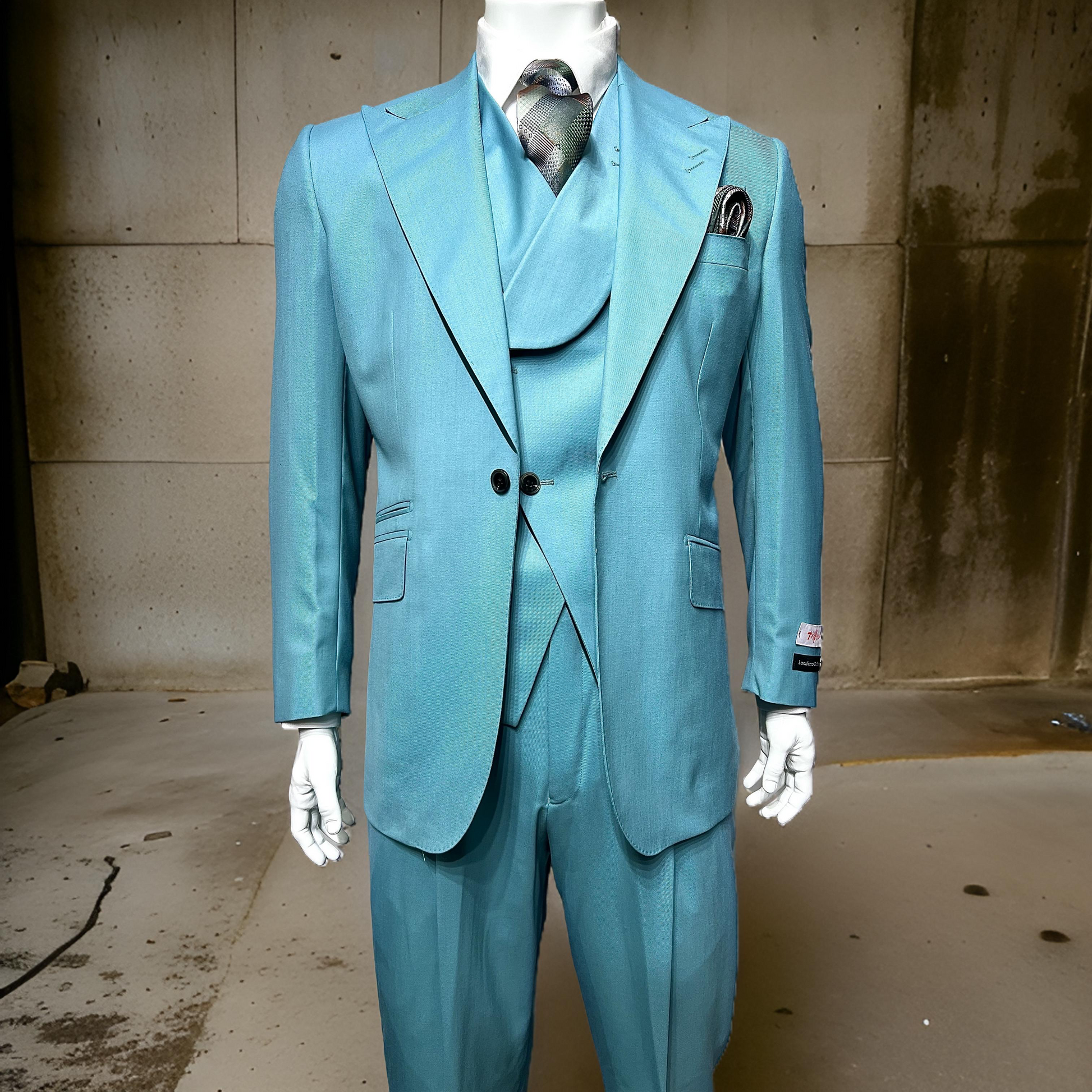 A mannequin displays an eye-catching Tiglio Rosso "New Rosso" seafoam wide-leg pure wool suit and vest, enhanced with a coordinating tie and pocket square. It is positioned against a stark concrete wall, fusing elegance with contemporary design.