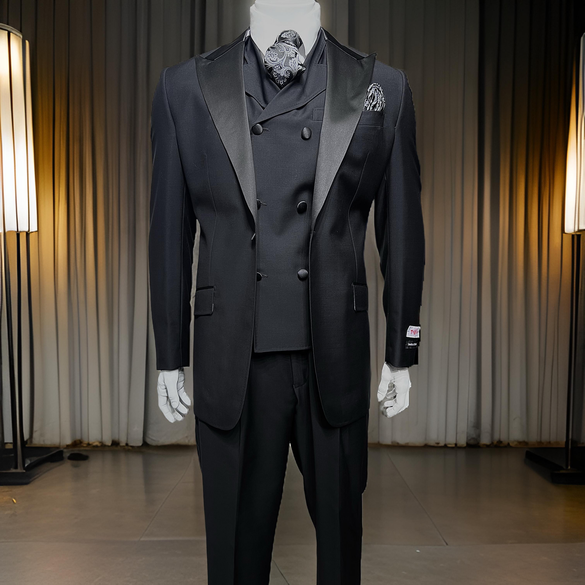 The Tiglio Rosso San Giovesse Black Tuxedo TIG1001, a three-piece suit featuring a satin lapel and paired with a patterned pocket square and paisley tie, is displayed on a mannequin in front of floor lamps and a curtain backdrop.