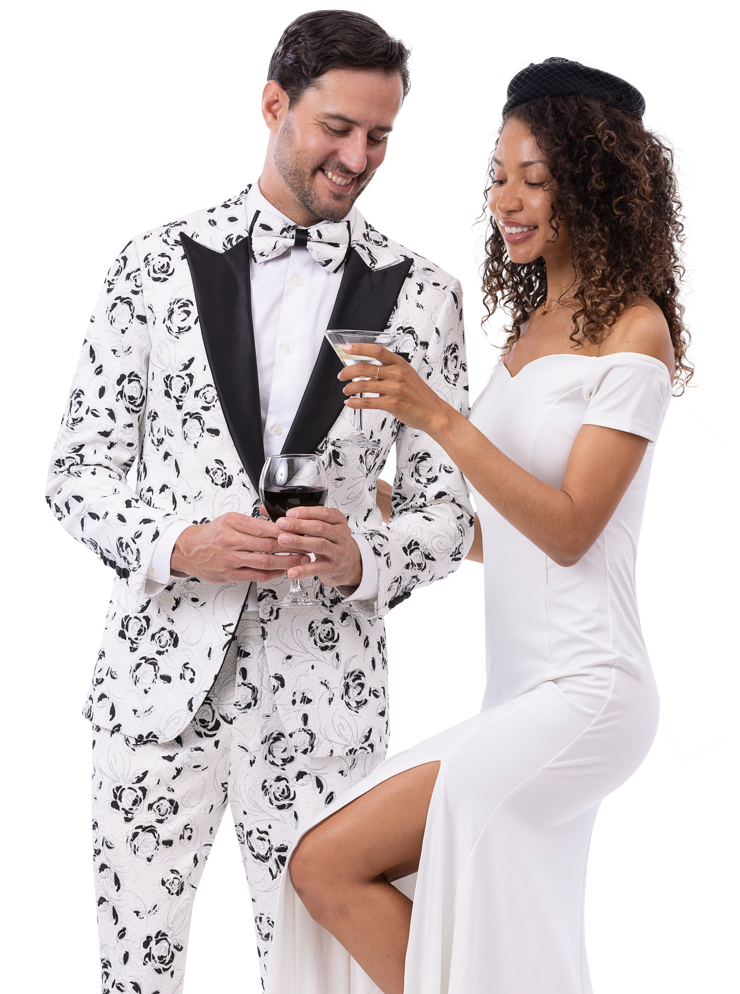 A man dressed in the EJ Samuel Wht/Blk Suit JP126 from EJ SAMUEL and a woman in an off-shoulder white dress hold drinks, smiling at each other.