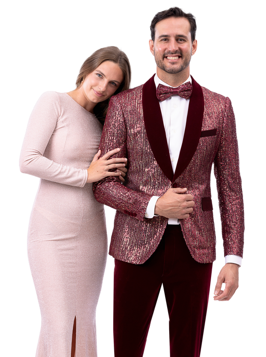 A woman in a long light pink dress leans on a man wearing the EJ Samuel Wine Suit JP131 by EJ SAMUEL, complete with a bow tie.