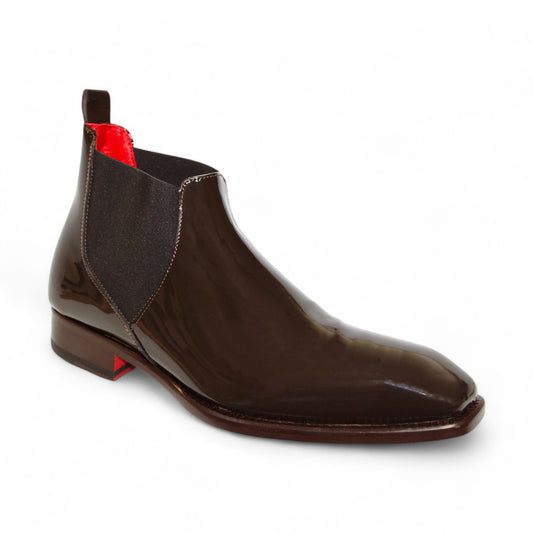 The Emilio Franco "Leonardo" Chocolate Boot is a glossy brown patent leather Chelsea boot featuring black elastic side panels and a brown sole, showcasing exquisite Italian craftsmanship in its side profile.