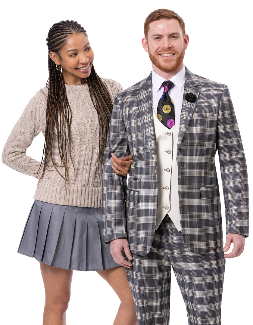 A woman in a beige sweater and gray skirt stands smiling next to a man dressed in the EJ Samuel Charcoal Suit M2805, a stylish ensemble by EJ SAMUEL featuring a reversible vest.