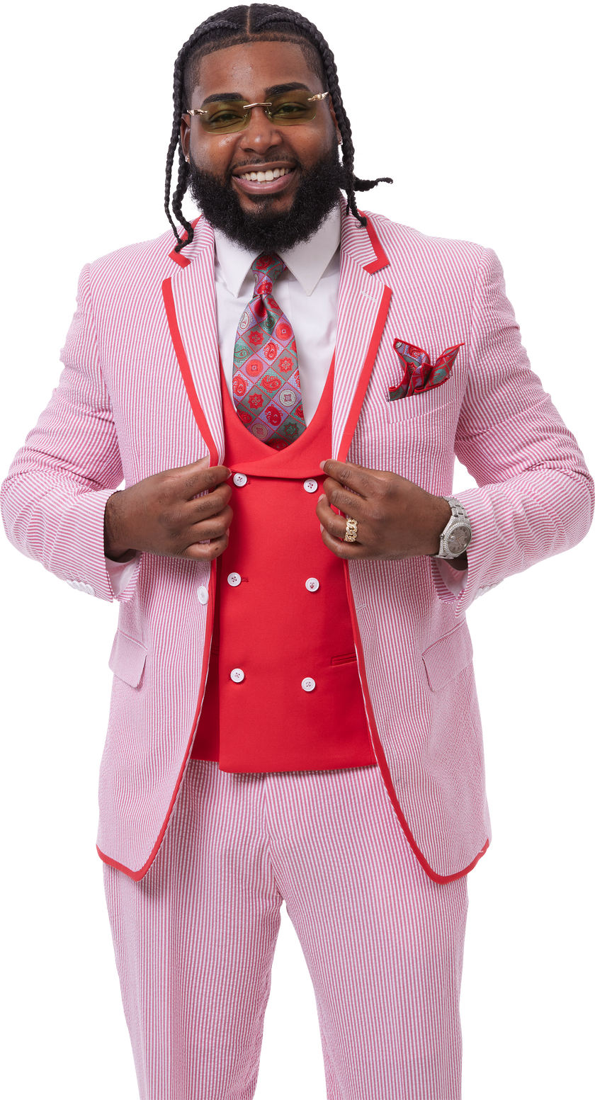 A person in an EJ Samuel Red Suit M2809, paired with a patterned tie and matching pocket square, smiling while adjusting the jacket of their 3-piece suit by EJ SAMUEL.