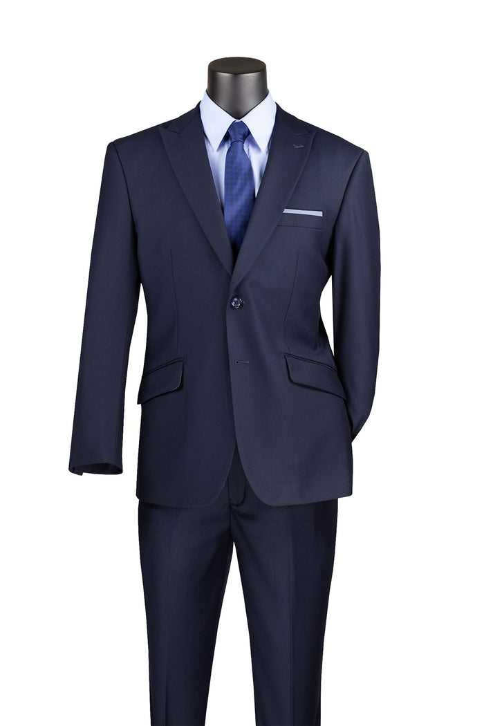 A black mannequin is showcased against a white background, dressed in a Vinci Suits Modern Fit Suit with Peak Lapel Navy M2TR, complemented by a wrinkle-resistant dark suit over a white shirt and blue tie.