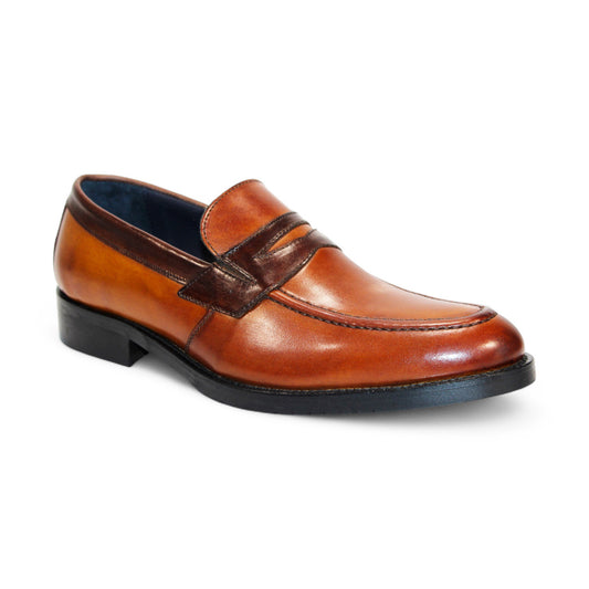 The Firmani Mark Cognac/Brown Shoes, featuring a classic design with a slight heel and rich dark detailing on the strap and edge, are crafted from premium brown leather and displayed against a white background.