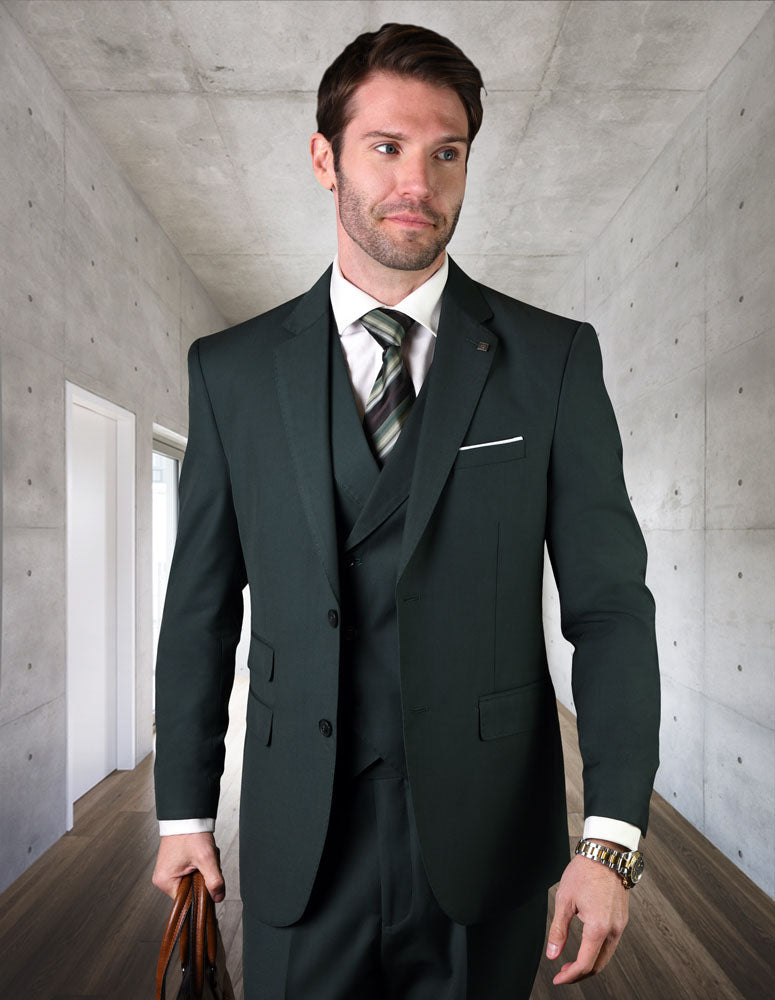 A man dressed in a STATEMENT CLOTHING | MESSINA-HUNTER Italian wool suit and tie stands in a modern hallway, holding a brown bag.