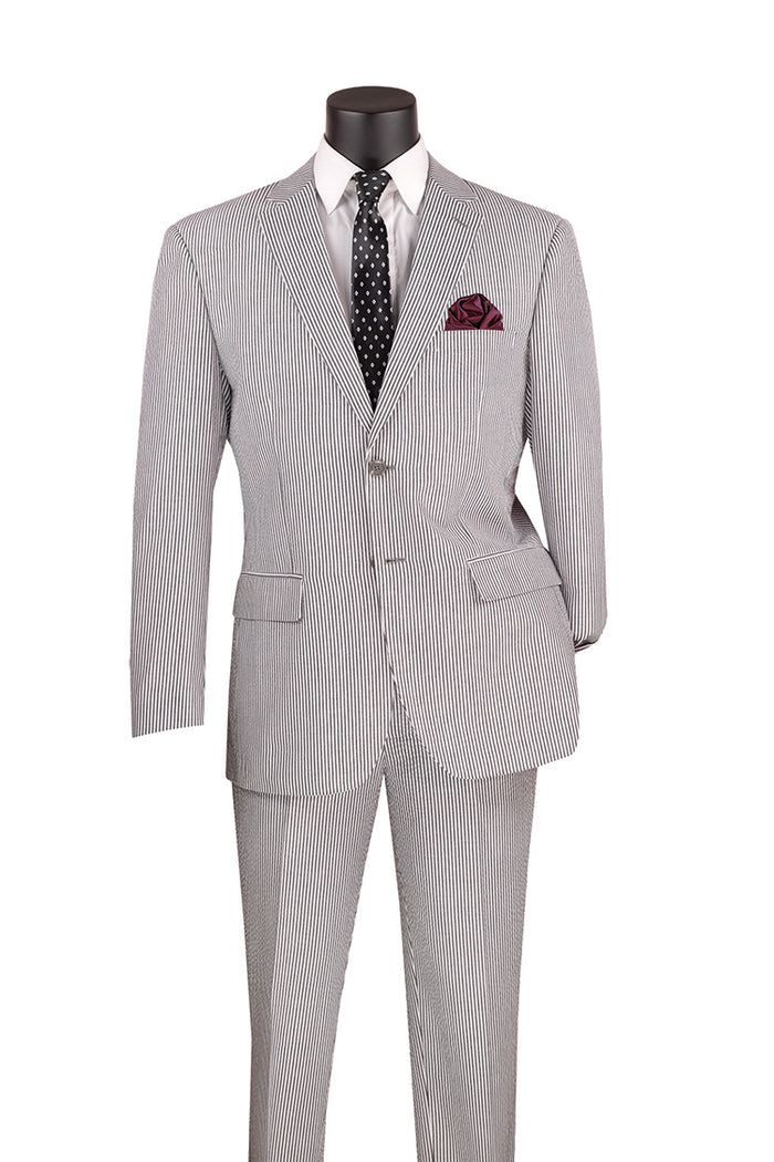 A modern fit suit on a mannequin, showcasing the Vinci Modern Fit Summer 2 Piece 2 Button Suit Striped Seersucker in black by Vinci Suits, is styled with a white shirt, black polka dot tie, and burgundy pocket square. This elegant ensemble exudes the timeless charm of classic fashion.