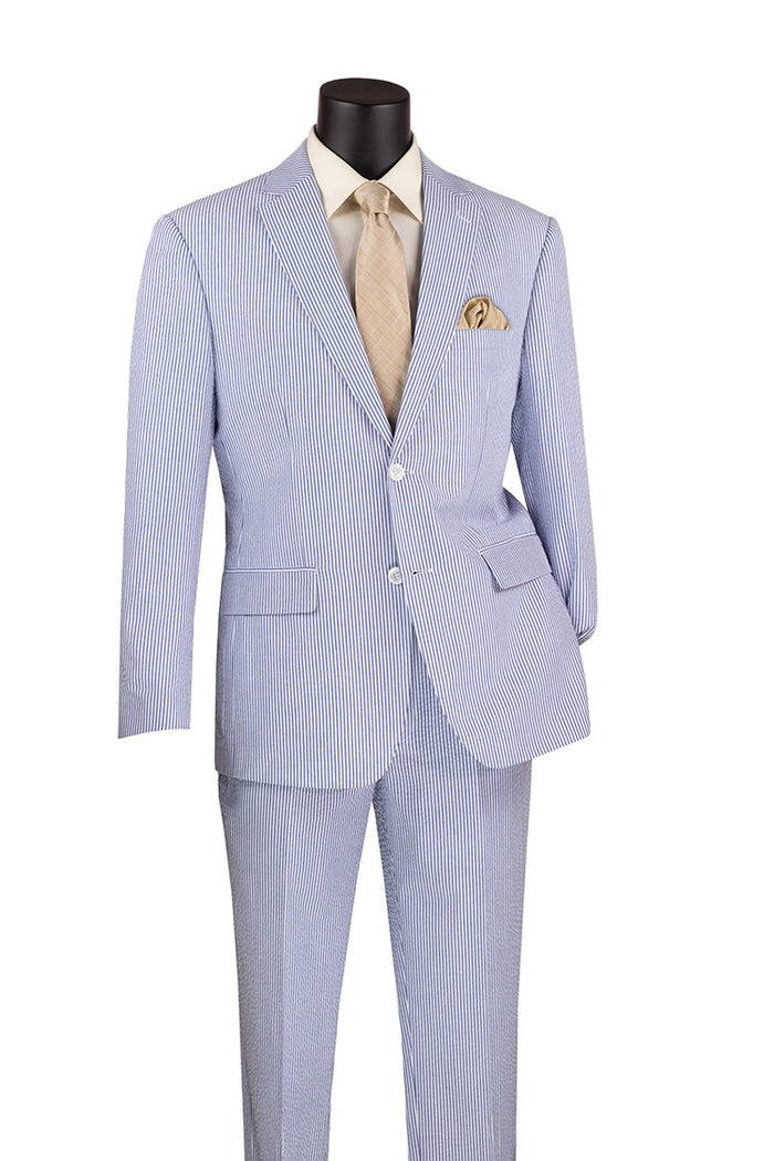 Displayed on the mannequin is the Vinci Suits Modern Fit Summer 2 Piece 2 Button Suit, featuring a striped seersucker design in a stylish navy. It includes both a coordinating jacket and pants, complemented by a beige shirt, tie, and a tan pocket square for an elegant ensemble.