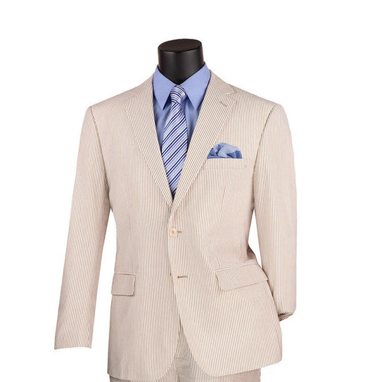 Displayed on a mannequin is the Vinci Modern Fit Summer 2 Piece 2 Button Suit in Tan Seersucker by Vinci Suits, complemented with a blue dress shirt and striped tie. This ensemble is tastefully finished with a coordinating pocket square, embodying effortless sophistication.