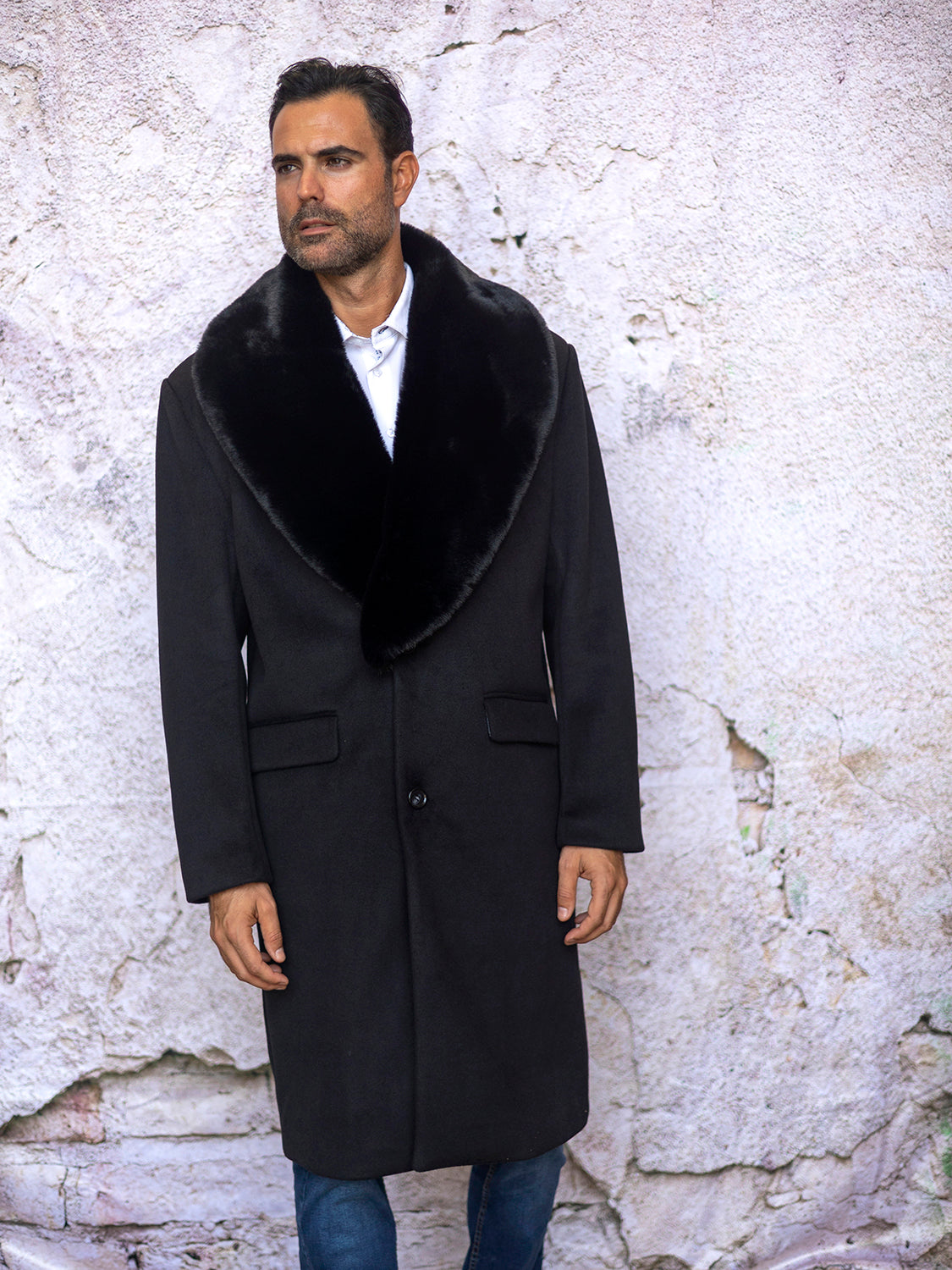 A person wearing the Insomnia MZW-321 Black Fancy 3/4 Coat with a removable faux fur collar stands in front of a textured wall.