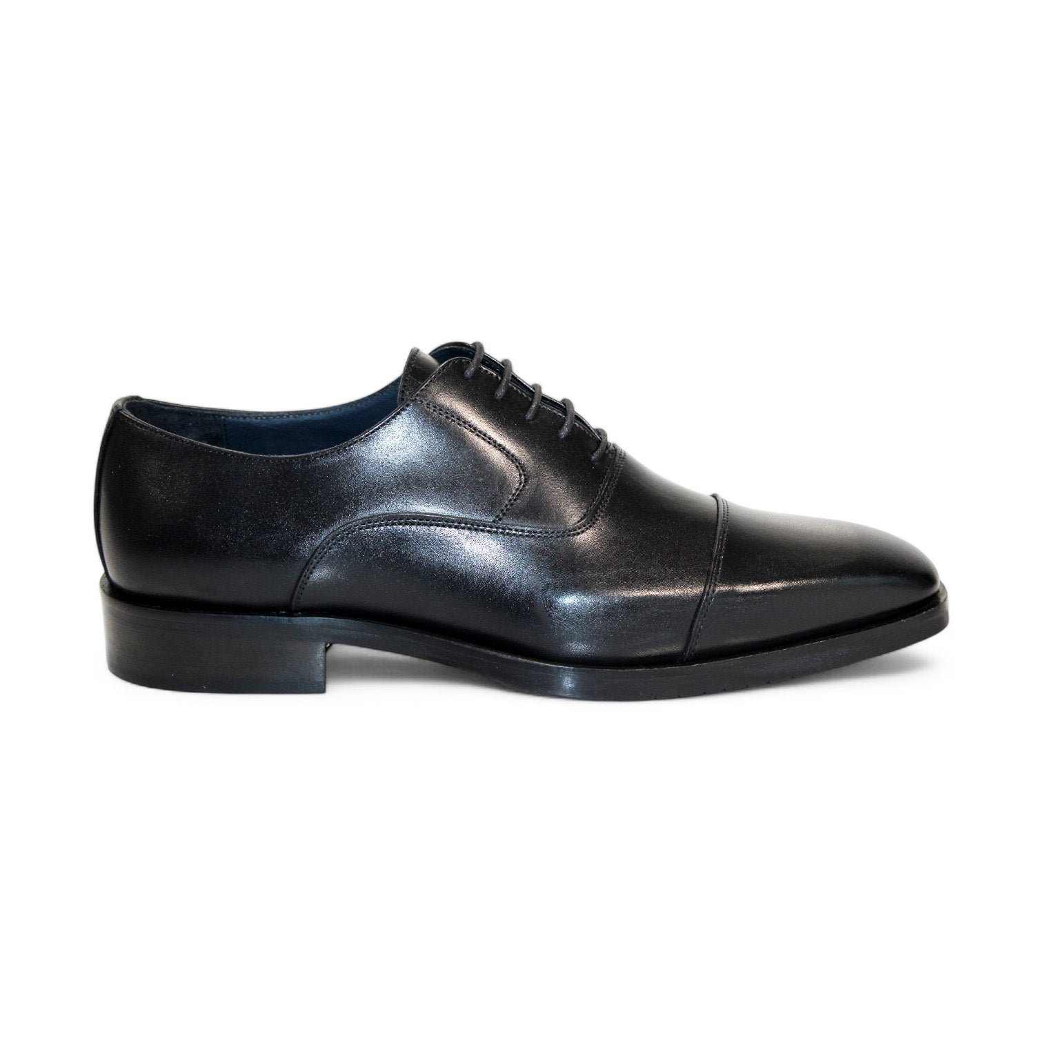 The Firmani Owen Black Shoes feature a solitary black leather dress shoe with laces, highlighting a cap toe design and low heel, as seen from the side. Masterfully crafted in Italy by Firmani, it represents timeless elegance and expert craftsmanship.