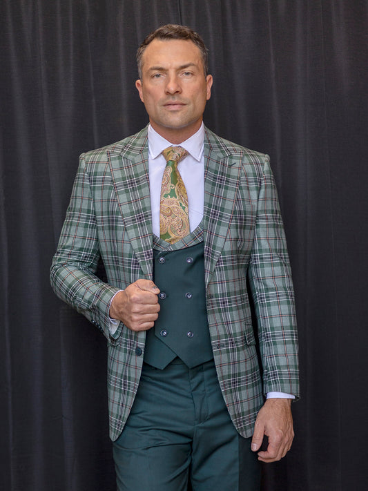 A man in an Insomnia Paris-3 three-piece tailored fit hunter suit with a patterned tie stands composedly in front of a black curtain.