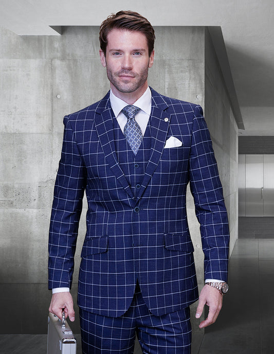 A man wearing a sophisticated STATEMENT CLOTHING | POMELO-SAPPHIRE suit from Statement Clothing, complete with a tie and pocket square, is holding a briefcase in a modern office setting.