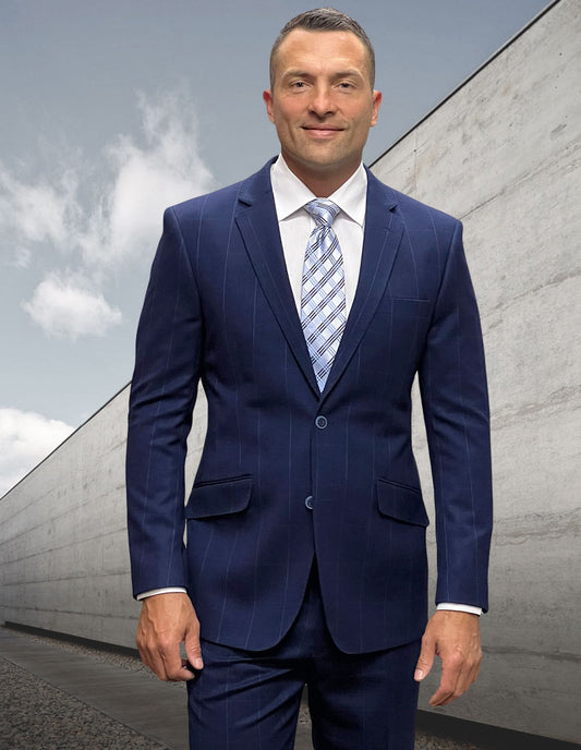 A person in a modern fit blue pinstripe suit and tie from Statement Clothing's STATEMENT CLOTHING | PORTO-1-COBALT collection, crafted from Italian wool, stands outdoors against a concrete wall under a cloudy cobalt sky.