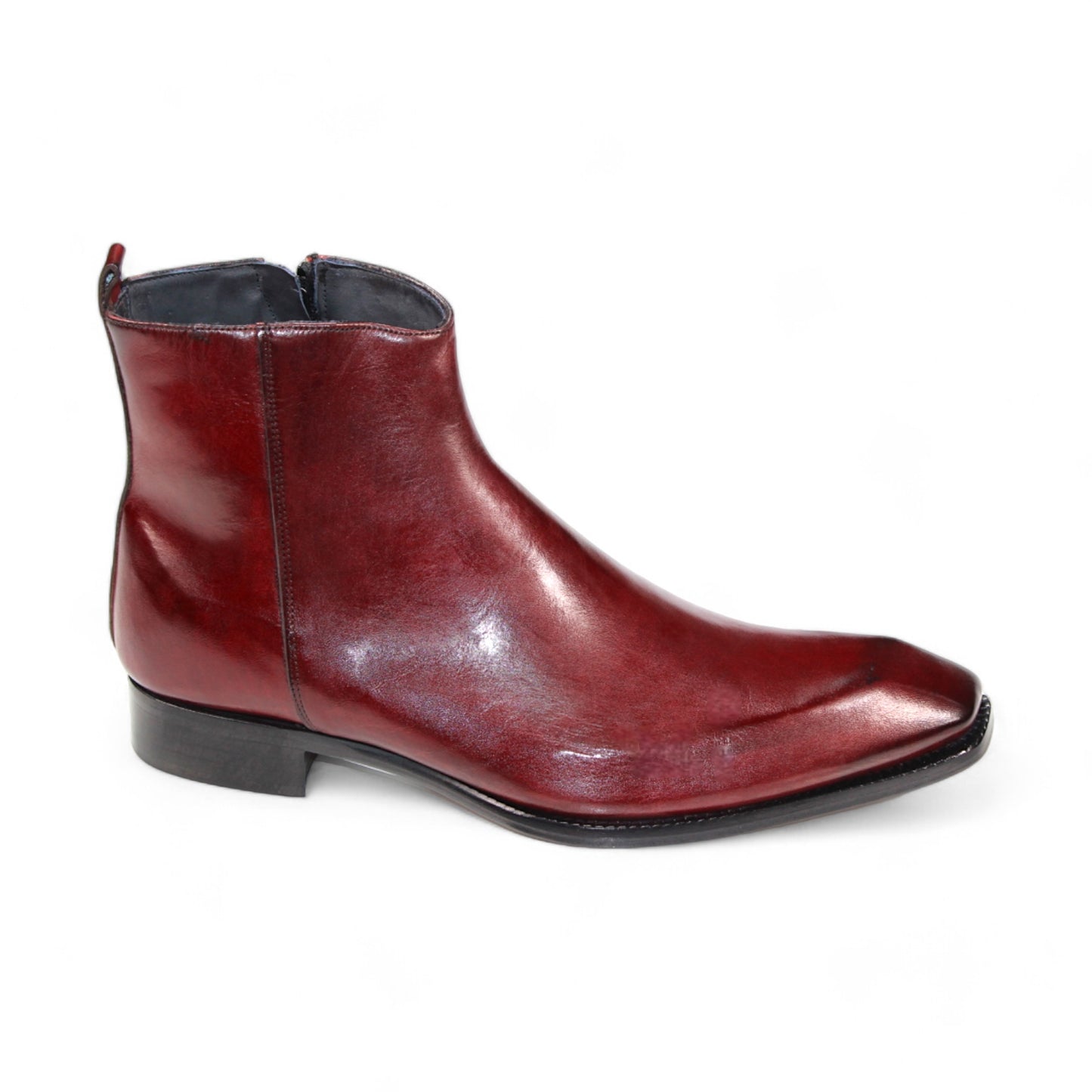 The Duca Di Matiste Romano (Cordovan) ankle boot is a polished, dark red footwear piece crafted from genuine leather, featuring a side zipper and a low black heel, made in Italy and displayed on a white background.