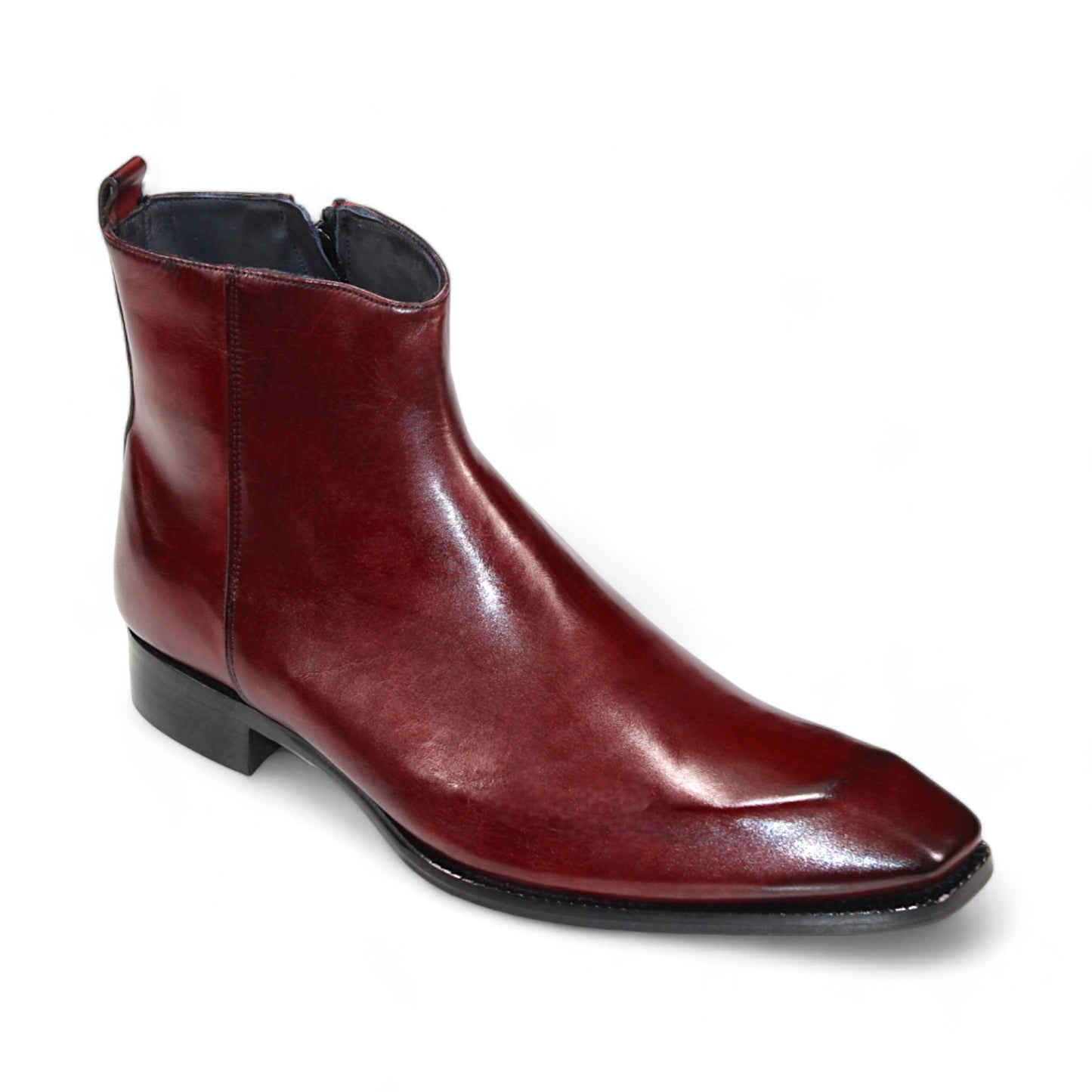 The Duca Di Matiste Romano (Cordovan) ankle boot is a polished, dark red footwear piece crafted from genuine leather, featuring a side zipper and a low black heel, made in Italy and displayed on a white background.