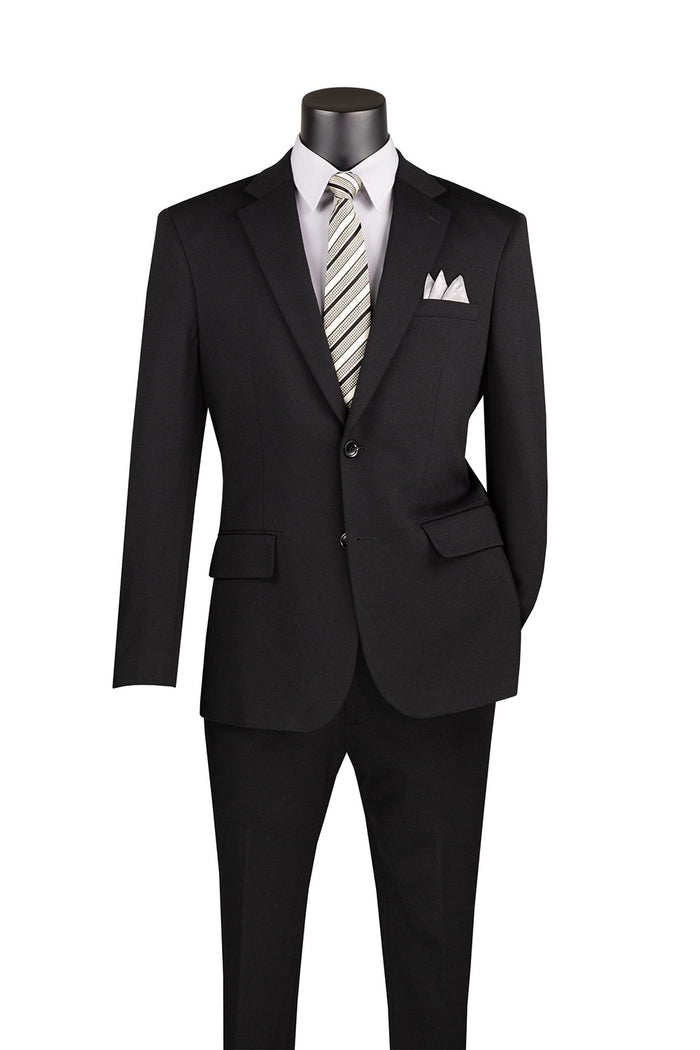 Displayed on a mannequin is the Vinci Slim Fit 2 Piece Suit by Vinci Suits, in black. This sleek ensemble includes a white shirt, a stylish striped tie, and an elegant pocket square, all crafted from stretch fabric for enhanced comfort and ease of movement. The suit features an adjustable waistband for added convenience.