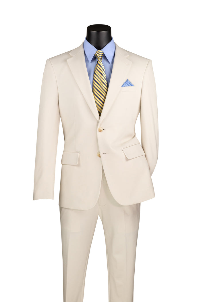 Displayed on a mannequin is the Vinci Slim Fit 2 Piece Suit in Bone SDX-3 by Vinci Suits. This ensemble includes a blue shirt with a striped yellow tie and a coordinating blue pocket square. Crafted from wrinkle-resistant stretch fabric, it guarantees both comfort and style for any occasion.