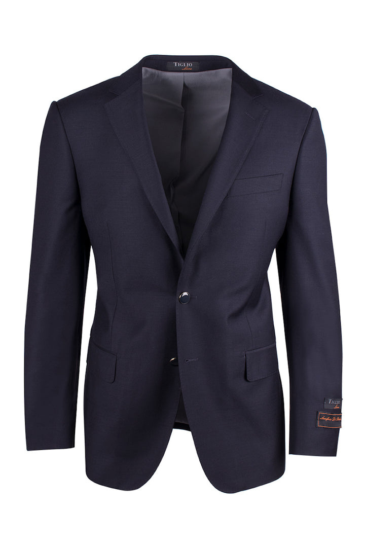 The Tiglio Luxe Navy Dolcetto Modern Fit, Pure Wool Jacket TIG1002 is a sophisticated dark navy blazer made from pure wool, showcasing Italian fabrics. It features two front buttons, notched lapels, and three pockets.