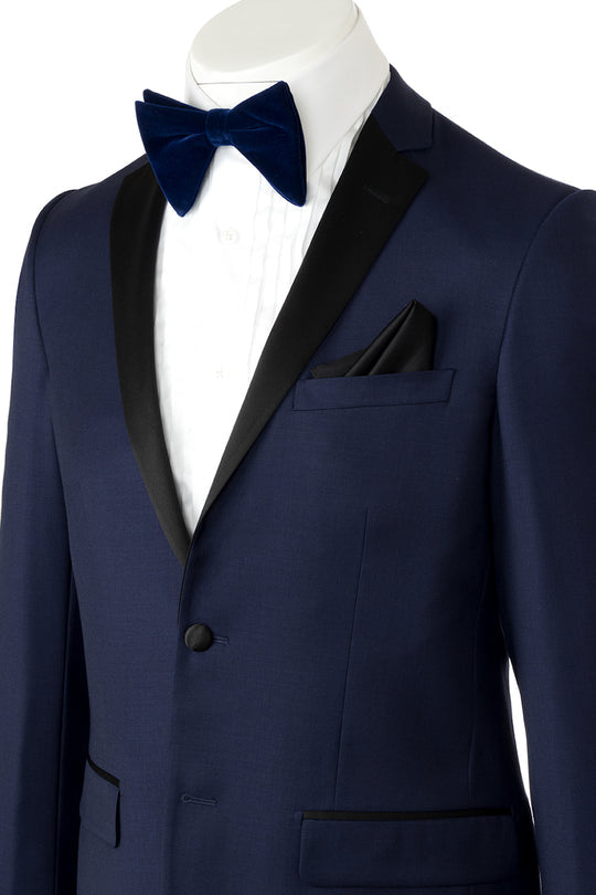 Discover the sophistication of the Tiglio Luxe Porto New Blue Tuxedo Tig1036, showcasing new blue with black satin lapels, crafted from premium Italian wool. This Tiglio creation offers a modern European fit and comes complete with a white dress shirt, black bow tie, and matching pants for an elegant ensemble.