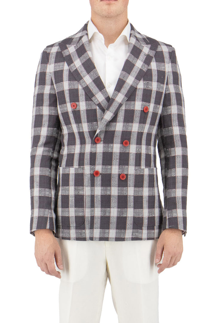 A person stands against a plain background wearing the Tiglio Luxe Slim Fit Half Lined Pure Wool Jacket in gray with a white and red windowpane pattern, featuring elegant red buttons, complemented by white trousers.